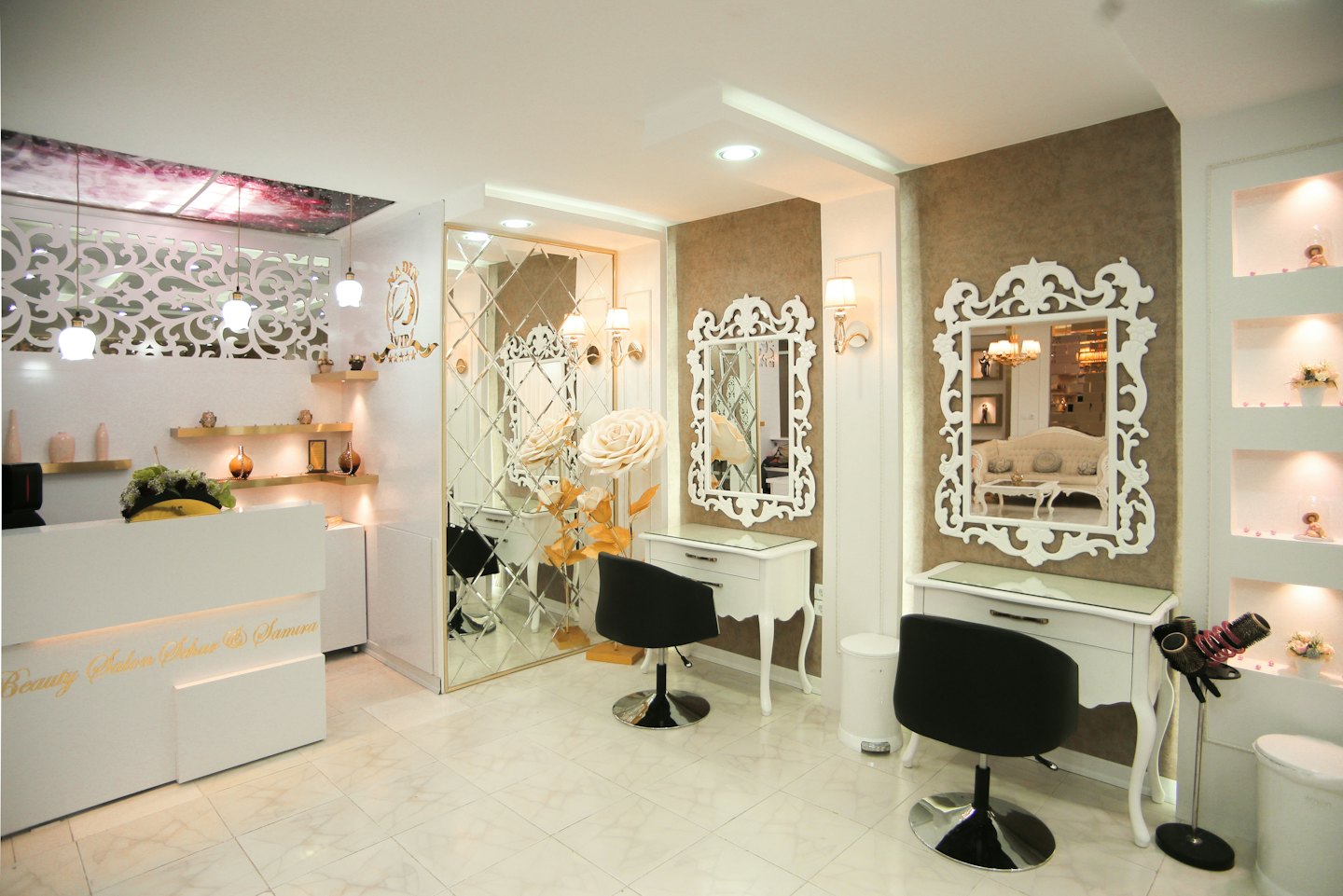 Empty luxury beauty salon with white reception desk and styling stations.